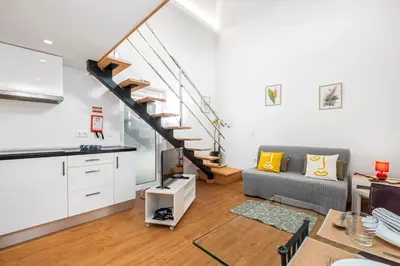 a living room with a couch and a staircase at Casa os Gauleses in Gaula
