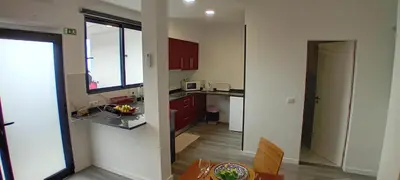 a kitchen with red cabinets and a table in a room at Vista Funchal Ⅰ in Funchal