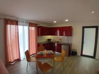a kitchen with a table and chairs and red cabinets at Vista Funchal Ⅰ in Funchal