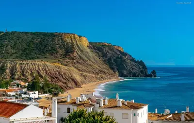 a view of a beach with houses and a cliff at A12 - Praia da Luz Center Apartment in Alagoas