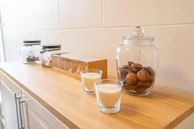 a counter with two glasses of orange juice and a jar of nuts at Serene Haven Retreat - Madeira Island in Caniço