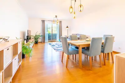 a dining room and living room with a table and chairs at Serene Haven Retreat - Madeira Island in Caniço