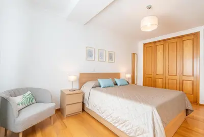 a bedroom with a bed and a chair at Serene Haven Retreat - Madeira Island in Caniço
