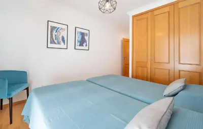 a bedroom with a blue bed and a blue chair at Serene Haven Retreat - Madeira Island in Caniço
