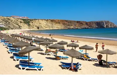 a large white building with cars parked in a parking lot at Beach & House''Villa Maria'' 5 min to Mareta Beach in Sagres