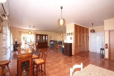 a kitchen and living room with a table and chairs at Quinta do Santo by LovelyStay in Santo da Serra