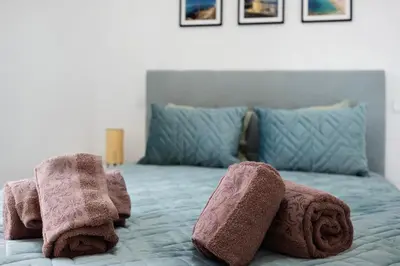 a bedroom with a bed with towels on it at Casinha in Burgau