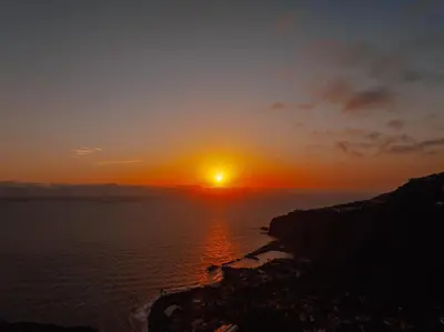 a sunset over the ocean with the sun in the sky at Lê Maison Deluxe Madeira - Where Peace is breathed and Luxury is felt! in Ribeira Brava