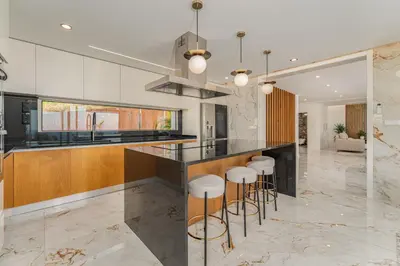 a kitchen with a counter and bar stools at Lê Maison Deluxe Madeira - Where Peace is breathed and Luxury is felt! in Ribeira Brava