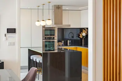 a kitchen with white cabinets and a black counter top at Lê Maison Deluxe Madeira - Where Peace is breathed and Luxury is felt! in Ribeira Brava