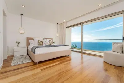 a bedroom with a bed and a large window at Lê Maison Deluxe Madeira - Where Peace is breathed and Luxury is felt! in Ribeira Brava