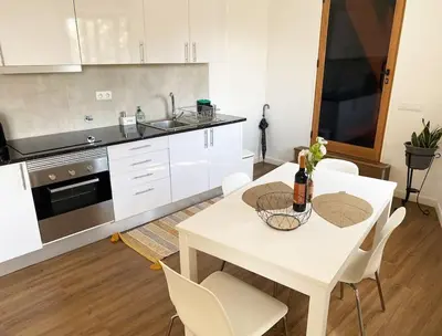 a kitchen with a white table and white chairs at Machico center w/ terrace 5 min beach in Machico
