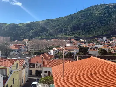 a city with houses and a mountain in the background at Machico center w/ terrace 5 min beach in Machico