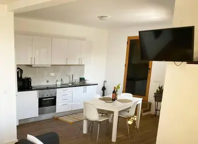 a kitchen with a white table and white chairs at Machico center w/ terrace 5 min beach in Machico