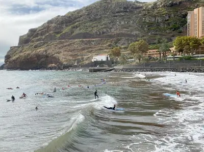 a group of people in the water at a beach at Machico center w/ terrace 5 min beach in Machico