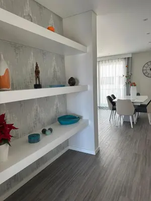 a living room with white shelves and a dining room at Raphael Funchal Views Apartment in Funchal