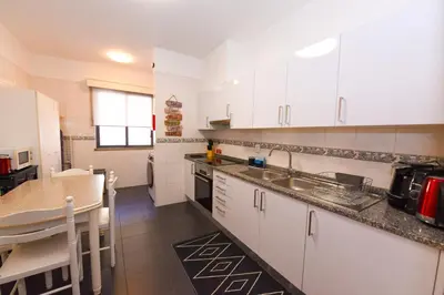 a kitchen with white cabinets and a counter top at Farinha's Apartment in Ribeira Brava