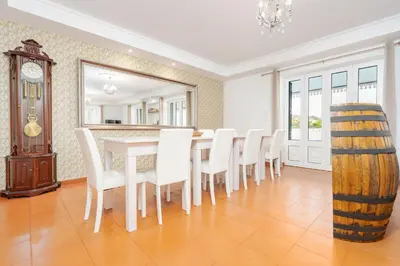 a dining room with a table and chairs and a clock at Casa Pereira in Relógio do Poiso