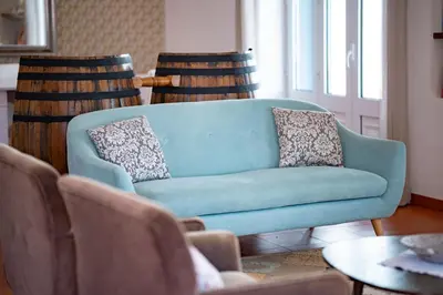 a blue couch in a living room with chairs at Casa Pereira in Relógio do Poiso