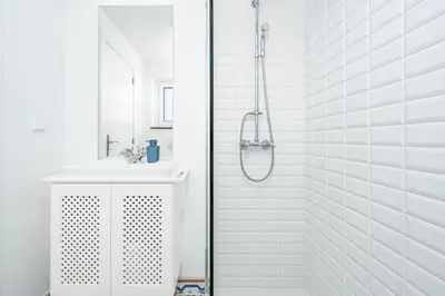 a white bathroom with a shower and a sink at Casa Pereira in Relógio do Poiso