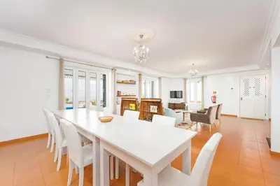 a white dining room with a white table and chairs at Casa Pereira in Relógio do Poiso