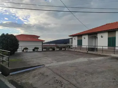 a parking lot in front of two buildings at Casa Câmara in Arco da Calheta