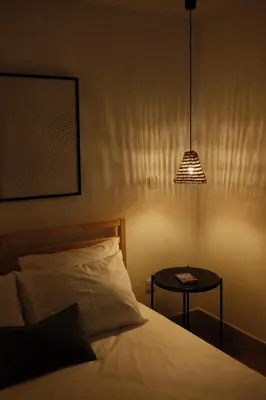 a bedroom with a bed and a table with a lamp at CASA15 Guesthouse Funchal in Funchal