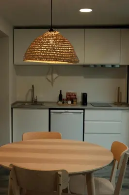 a table and chairs in a kitchen with a light fixture at CASA15 Guesthouse Funchal in Funchal