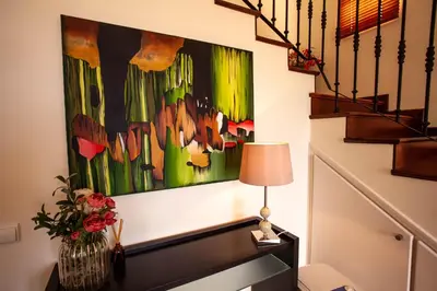 a desk with a lamp and a painting on the wall at Villa Margarida in Ponta do Sol