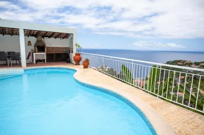 a swimming pool with a view of the ocean at Villa Margarida in Ponta do Sol