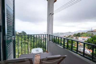 a balcony with chairs and a view of the city at Casa Monte by GALMI in Funchal