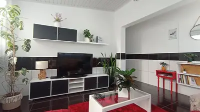 a living room with a flat screen tv on a wall at Kanela Guest House in Machico