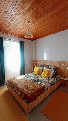 a bedroom with a bed and a table with a lamp at Kanela Guest House in Machico