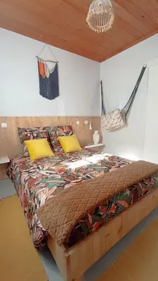 a bedroom with a large bed with a wooden ceiling at Kanela Guest House in Machico