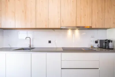 a kitchen with a sink and wooden cabinets at SkyView Penthouse Apartment by MHM in Funchal
