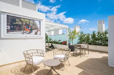 a patio with chairs and tables and a large window at SkyView Penthouse Apartment by MHM in Funchal