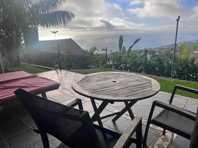 a wooden table and chairs sitting on a patio at Lucky Lemons - Boutique Houses Madeira (Studio) in Calheta