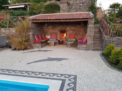 a patio with chairs and a fireplace next to a pool at Lucky Lemons - Boutique Houses Madeira (Studio) in Calheta