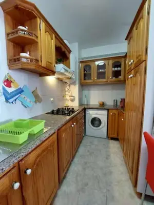 a kitchen with wooden cabinets and a washing machine at Barbara Home in Madalena do Mar