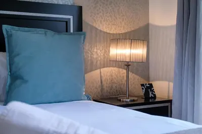 a bedroom with a bed with a blue pillow and a lamp at GuestReady - Scenic Retreat with Seaview in Funchal