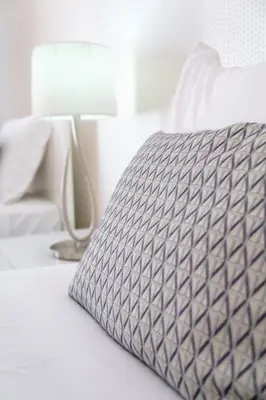 a bed with a gray pillow on top of it at GuestReady - Scenic Retreat with Seaview in Funchal