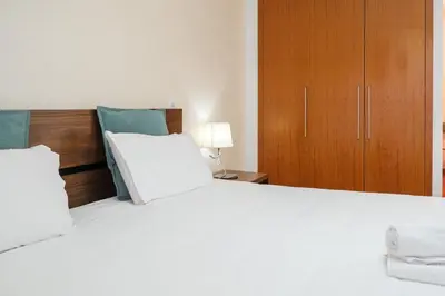 a bedroom with a large bed and a wooden cabinet at GuestReady - Scenic Retreat with Seaview in Funchal