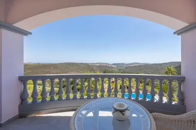 a table with a vase on a balcony at Villa Surga, a luxurious and exclusive romantic villa in the Algarve in Budens