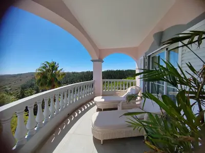 a balcony with chairs and a view of the mountains at Villa Surga, a luxurious and exclusive romantic villa in the Algarve in Budens