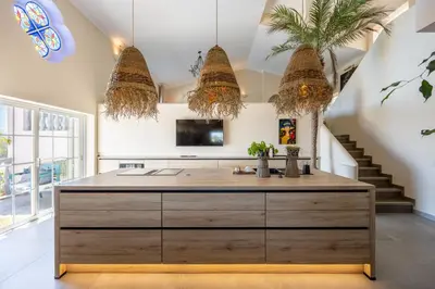 a kitchen with a large island in a room with stairs at Villa Surga, a luxurious and exclusive romantic villa in the Algarve in Budens