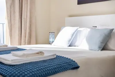 a white bed with white pillows and towels on it at Blue Ocean Villa in Ponta do Sol