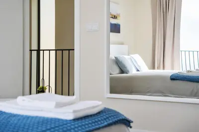 a bathroom with a mirror and a bed in a room at Blue Ocean Villa in Ponta do Sol