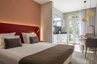 a bedroom with a large bed with a red headboard at King David Suites by Homie in Funchal