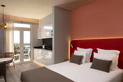 a hotel room with a large bed with a red headboard at King David Suites by Homie in Funchal