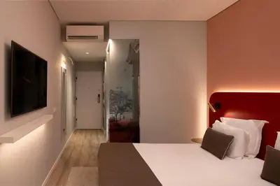 a bedroom with a large bed with a red headboard at King David Suites by Homie in Funchal